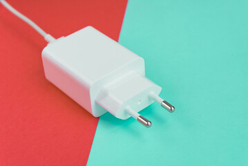 Charger and USB cable type C over pink and blue background