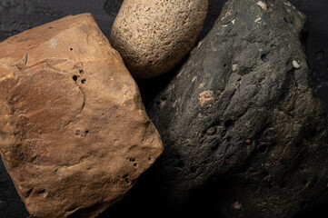 Rocks and stone textures up close, black rock, tan rock and round rock.