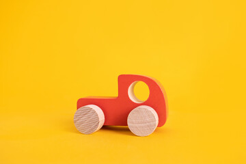 Wooden toy car in cartoon style on yellow background. Colorful and Transportation background, eco kid toys Montessori . 
