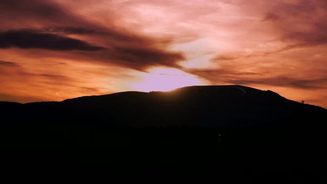 Heavenly golden sunset timelapse over a natural mountain backdrop.