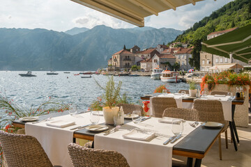 Outdoor restaurant in Perast village in Kotor Bay, Montenegro. - obrazy, fototapety, plakaty