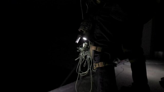 Close up of Paracord Knot with Rifle Sling and Tactical Gun Fighter Military Operation Rappel Down the Interior of a Dark Building, Gearing Up in Preparation for Assault