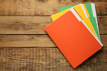 Different files with documents on wooden table, top view. Space for text