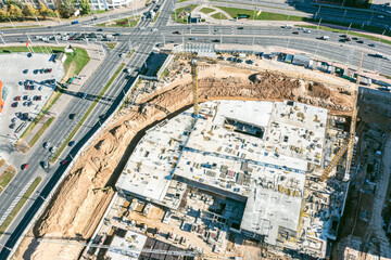 new shopping mall under construction. aerial view of busy construction site with cranes and building materials.