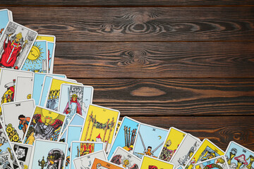 Fototapeta na wymiar Tarot cards on wooden table, top view. Space for text
