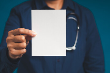 Doctor hand holding a blank white paper while standing on a blue background.