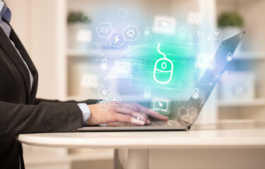 Hands working on laptop with digital icons