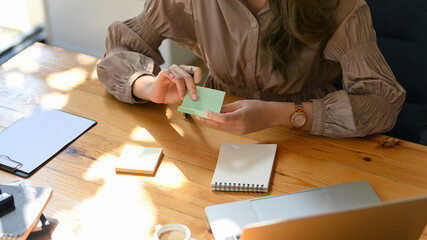 A woman listing an importance topics on sticky notes