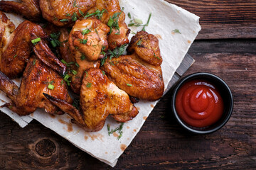 Barbecue chicken wings on rustic wooden table background. Top view. Copy space 