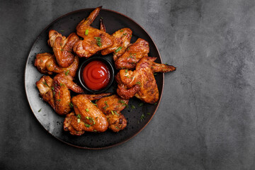 Barbecue chicken wings on rustic wooden table background. Top view. Copy space 