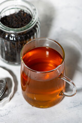 black tea in a glass cup and ingredients for brewing, closeup photo top view