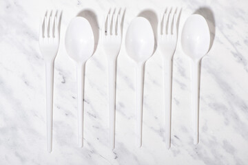 plastic spoons and forks on a white background