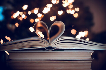 Paper book in the shape of a heart 
 on a bokeh background. valentine's day. love symbol