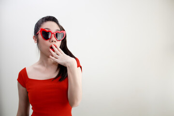 Asian shocked women wearing red glasses and covering mouth with hands with fabulous secret and shocked.
