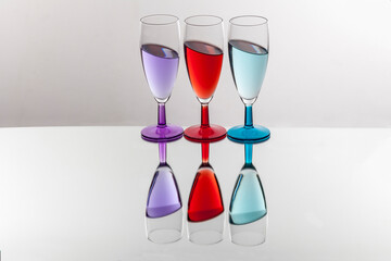 Fototapeta na wymiar goblets filled with colored liquids white background