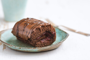 Delicious chocolate roll cake with  icing  and cherry filling. Drunk cherry cake