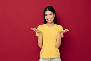 Portrait Asian beautiful young woman yellow casual t shirt smile posing red background unaltered