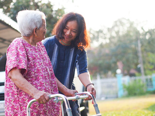 Portrait of old mother with cheerful woman taking care of her mom. Happy Asian senior family...