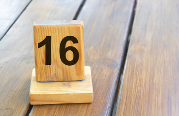 Wooden priority number 16 on a plank tab