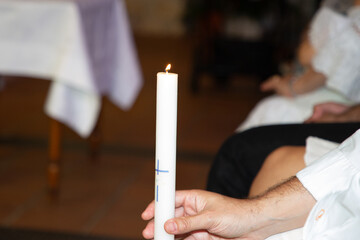 burning candle in man father hands during Baptism infant ceremony in Church