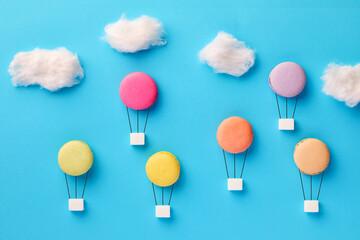 Macaroon or macarons and sugar cubes in the form of hot air balloons flying in the sky. Sugar diet, dieting and calories