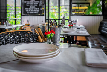 Art deco and colonial interior at a cafe with flowers on empty tables, Singapore