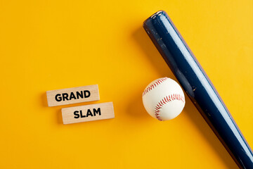 Baseball ball and wooden bat on yellow background with the words grand slam
