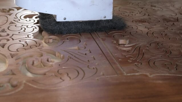 Woodworking CNC router machine cuts a pattern on a piece of wood.Close up,slow motion.