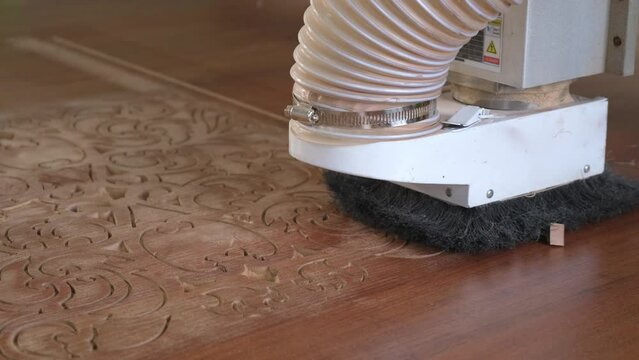 Woodworking CNC router machine cuts a pattern on a piece of wood.Close up,slow motion.
