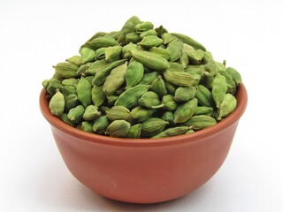 Green Cardamom in a bowl on white background 