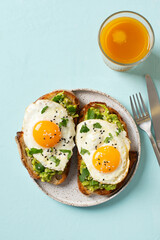 Healthy breakfast with eggs toast and orange juice on blue background