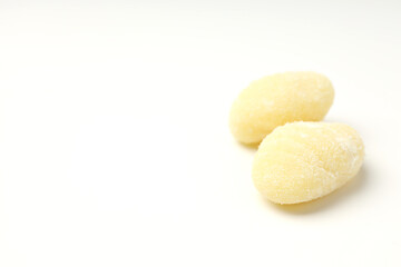 Raw potato gnocchi on white background, space for text