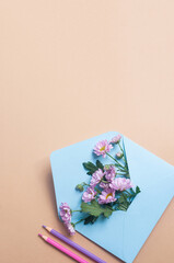 Blue pastel envelope on light yellow background with flowers message invitation concepts