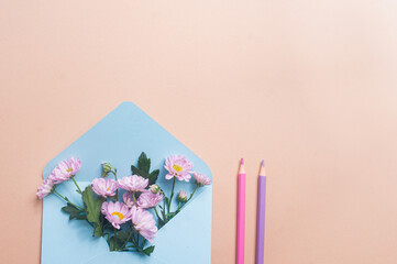 Blue pastel envelope on light yellow background with flowers message invitation concepts