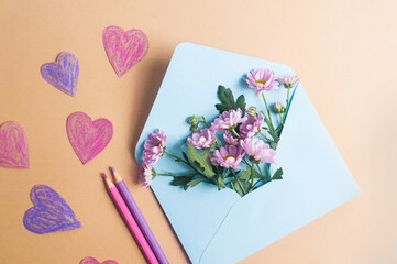 Light blue envelope with flowers and hearts on light yellow background valentines day spring...