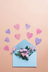 Light blue envelope with flowers and hearts on light yellow background valentines day spring concept copy space message email concept