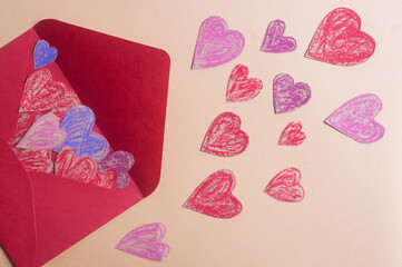 Valentine's day concept crayon hearts and red envelope copy space flat lay