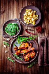 Marinated chicken drumsticks with baked potatoes and spinach