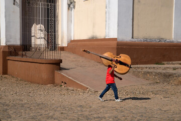 Cuba, Trinidad city, a boy carrying cello
