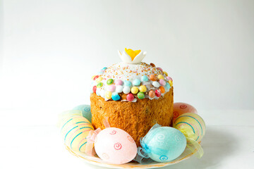 Easter cake with painted eggs on a platter in a gray interior. Traditional festive food