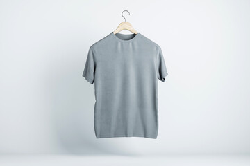 Blank grey t-shirt hanging in the air with copyspace for your text on light backdrop. 3D rendering, mockup