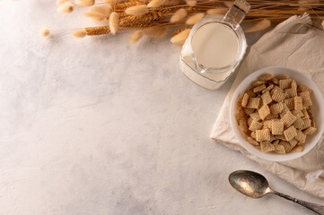 Cereal snacks, milk in a jug, a spoon and a bunch of cereals on a white background. High angle view. There is an empty space to insert. Quick breakfasts, sports, fitness, baby food.