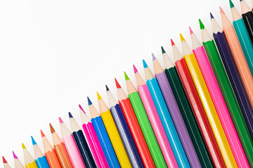 Fototapeta premium Wooden colored pencils isolated on a white background. A line of multicolored pencils in a large plan
