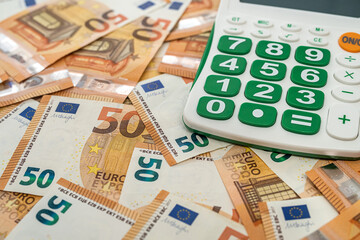new blank calculator with green buttons lies nicely on new euro banknotes