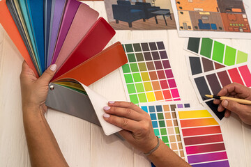 office workers consider a palette of colors that are selected for the design of a new kitchen.