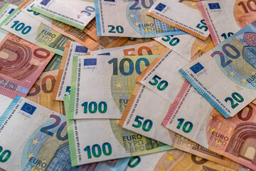 Beautiful multicolored new euro banknotes scattered in a pile on a spacious table.