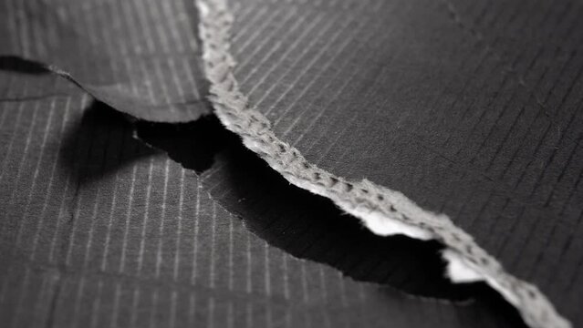 Torn black paper edge. Corrugated ripped cardboard layers. Macro. Rotation. Abstract view. Grunge surface - Powered by Adobe