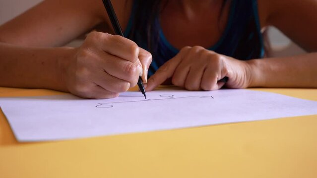 Genogram. Creative Woman Drawing Family Diagram On White Paper, Represented By Shapes Connected By Lines. close up