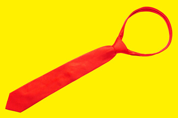 Red tie isolated on yellow background - obrazy, fototapety, plakaty