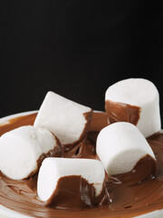 Close-up. White pieces of marshmallows in chocolate cream. Sweet food, holiday, birthday, hormones of happiness, romance, date. Restaurant, confectionery, advertising.